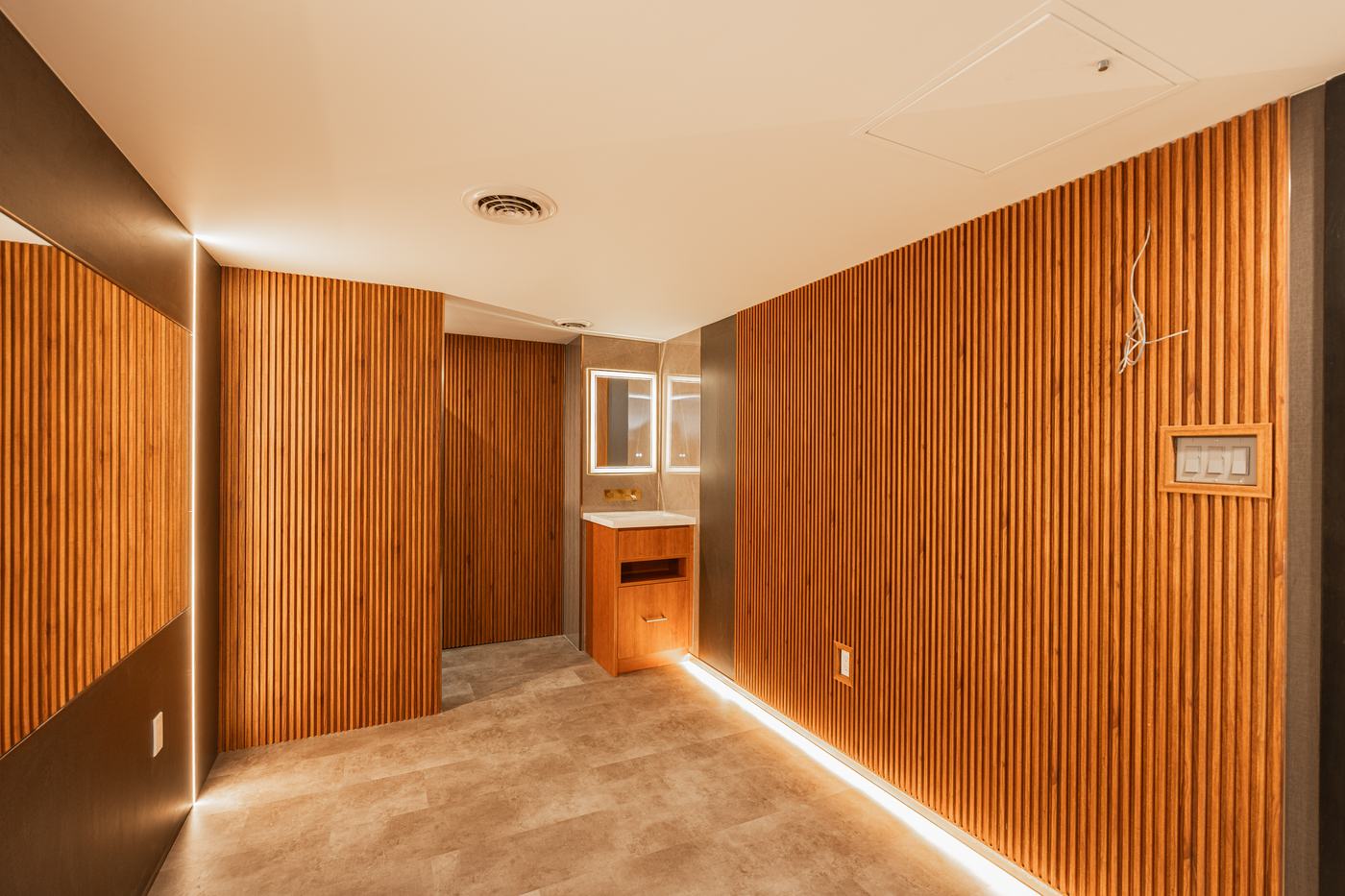 Crafted interior detail — wood-slat wall with integrated lighting on a Berm Inc. project