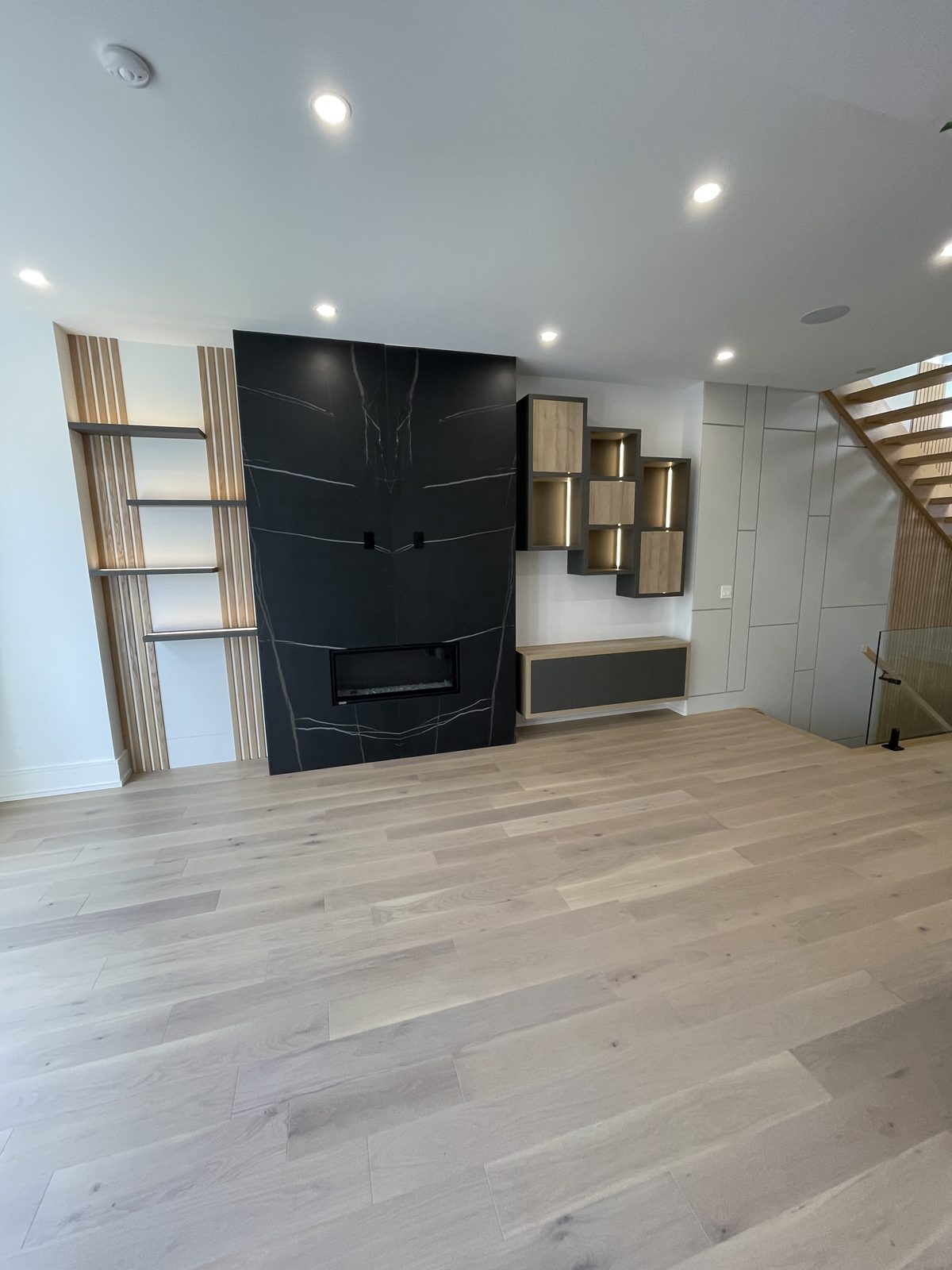 Fireplace feature wall with integrated millwork and lighting — Berm Inc. project photo